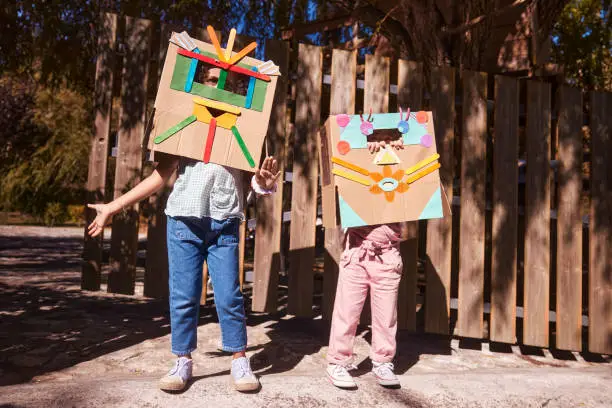 Photo of Two little girls dressed as robots having fun in garden