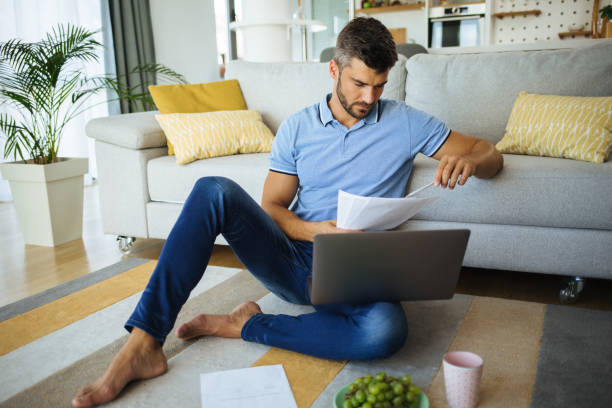 istock Mid adult man working from home using laptop 1271345631