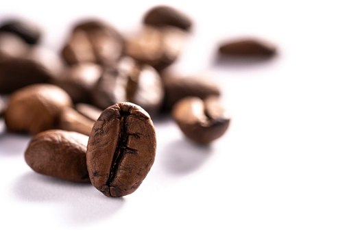 Macro coffee beans roasted closeup perspective isolated on white background