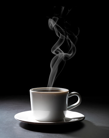 Coffee cup hot on dark black background with smoke