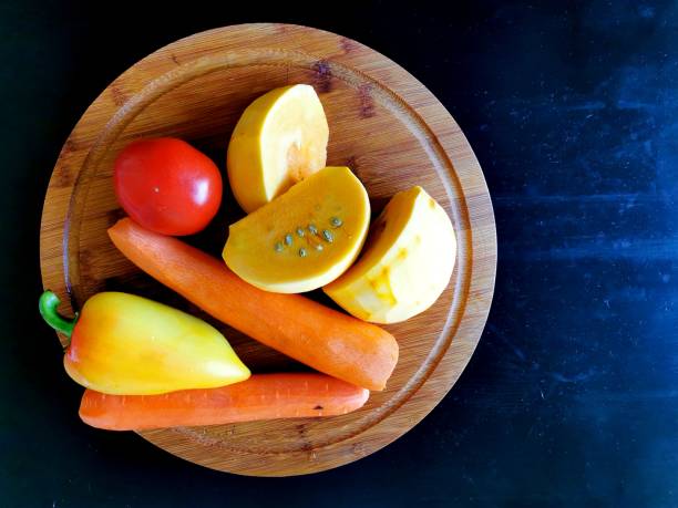 istock Vegetables (pumpkin, carrots, tomato and paprika) on a round wooden board, prepared for cooking soup 1271351886