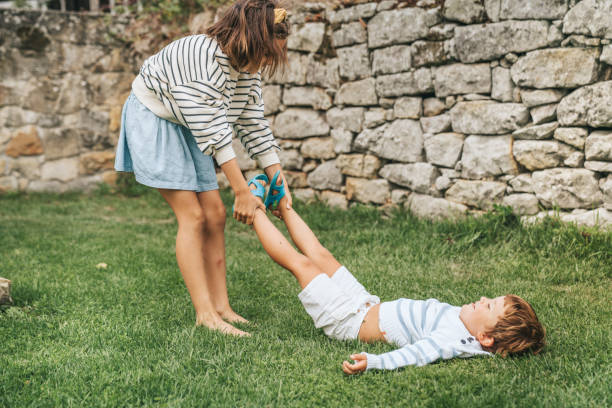 istock Brother and sisters having fun on garden lawn 1271354657