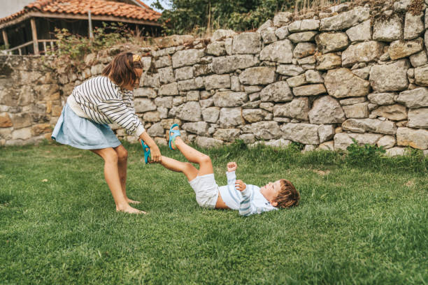 istock Brother and sisters having fun on garden lawn 1271354726