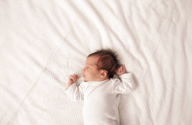 kuvapankkikuvat ja rojaltivapaat kuvat aiheesta söpö vastasyntynyt tyttövauva makaa sängyssä - one baby girl only