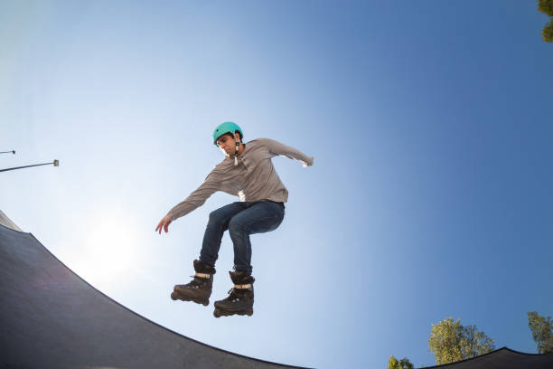 istock boy with inline skates, rollerblade, doing a jump in a skate park 1271367396