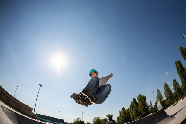 istock boy with inline skates, rollerblade, doing a jump in a skate park 1271367400