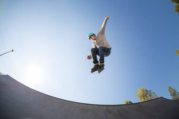 istock boy with inline skates, rollerblade, doing a jump in a skate park 1271367409