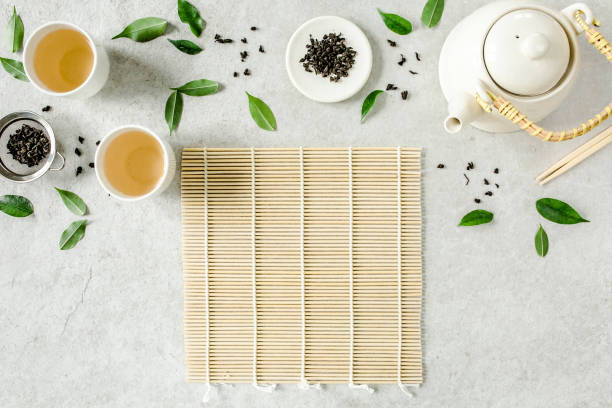 istock Herbal tea with two white tea cups and teapot, with green tea leaves. Flat lay, top view. Tea concept 1271369524