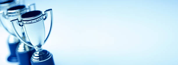 istock Row Of Trophies On Blue Background 1271371979