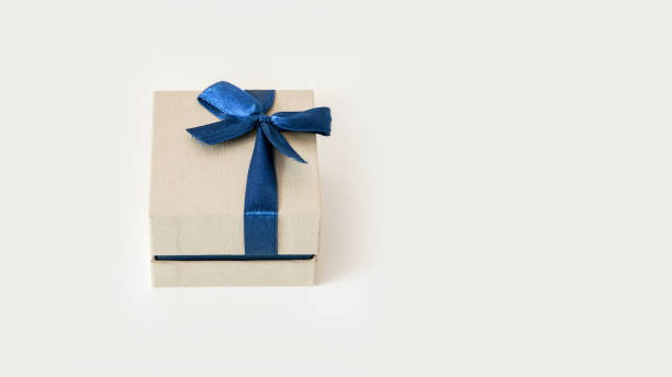istock small beige gift box wrapped with blue celebration tape isolated on white background 1271372859