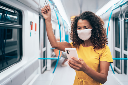 Young afro-american woman wearing face protective mask in the public transport