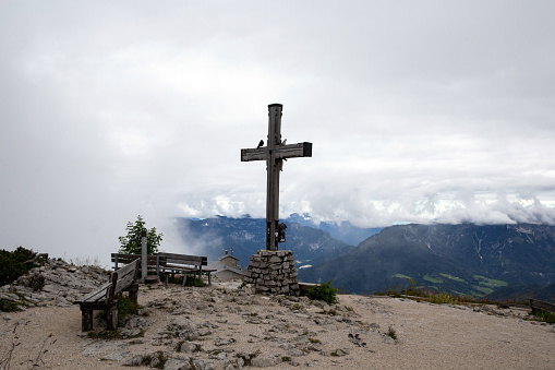 A summit cross on Hoher Burgstall with Habicht peak in background in austrian Stubai Alps.