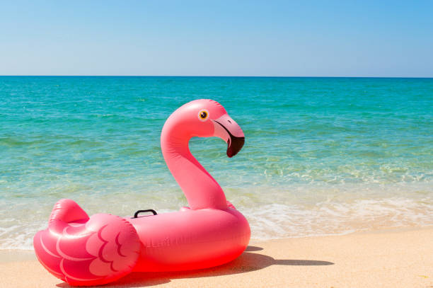 różowy nadmuchiwany materac flamingo na plaży z bliska. koncepcja turystyki, podróży, wakacji. - blue mattress vacations toy zdjęcia i obrazy z banku zdjęć