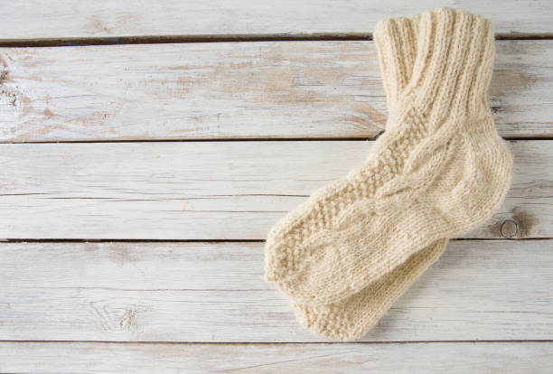 istock white knitted socks on wooden surface 1271385721