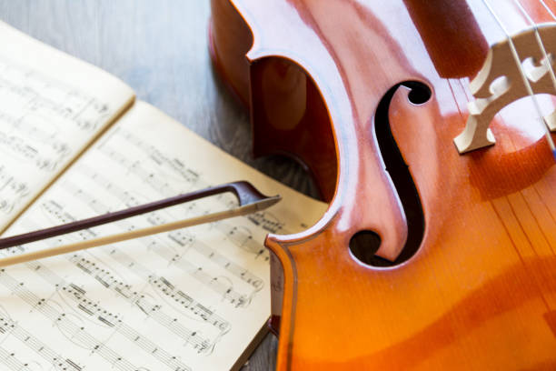 istock Cello and its bow with a music sheets on wooden background with copy space . Rehearsal before the concert. Musical tuition concept. 1271387541