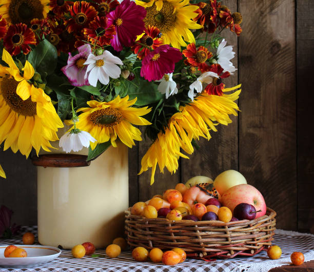 bouquet with sunflowers, apples and plums. garden still life with flowers and fruits.