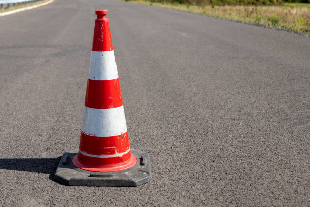 istock A single red striped traffic cone, pylon, on asphalt 1271393878