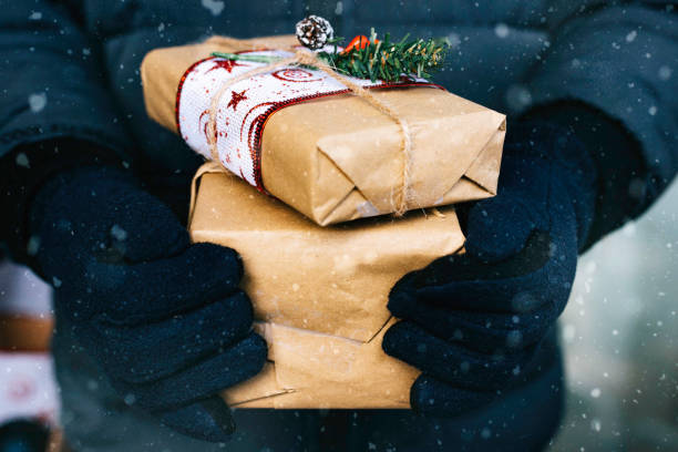 istock Boy holding a christmas present under the snow 1271394020
