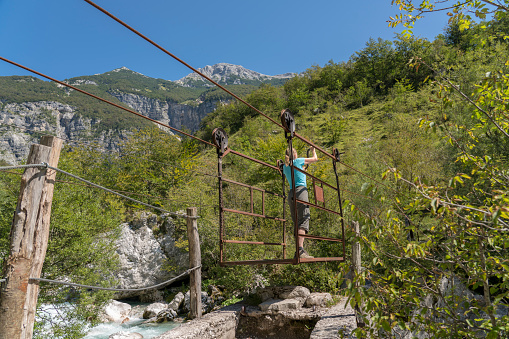 Mature women on hand-operating cable car crossing the Tolminka river in Municipal of Tolmin in beautifule nature of Triglav national park