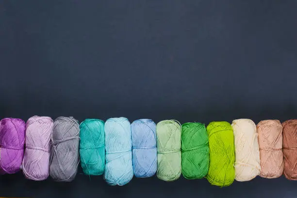 Colorful skeins of yarn on a gray-blue background. Studio shooting.