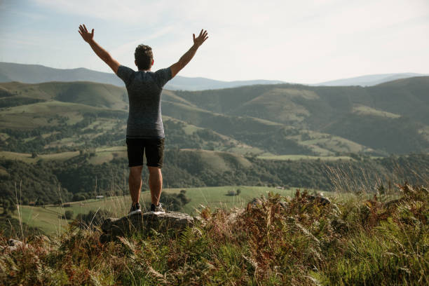 istock Young man with arms raised on top of a mountain 1271395702