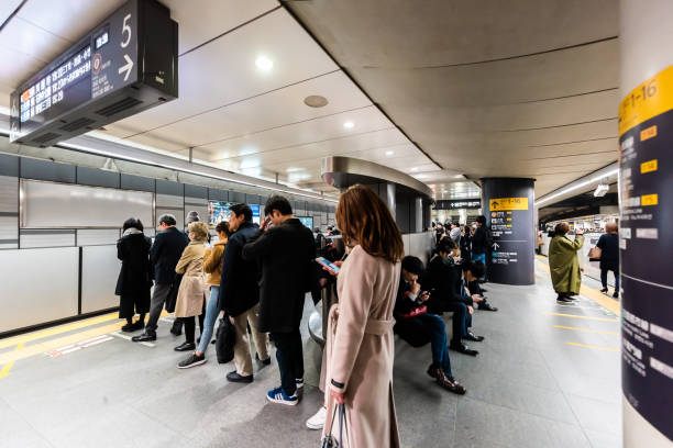 pessoas esperando na fila para vagão de trem na plataforma durante a hora do rush em tóquio - rush hour commuter on the phone tokyo prefecture - fotografias e filmes do acervo