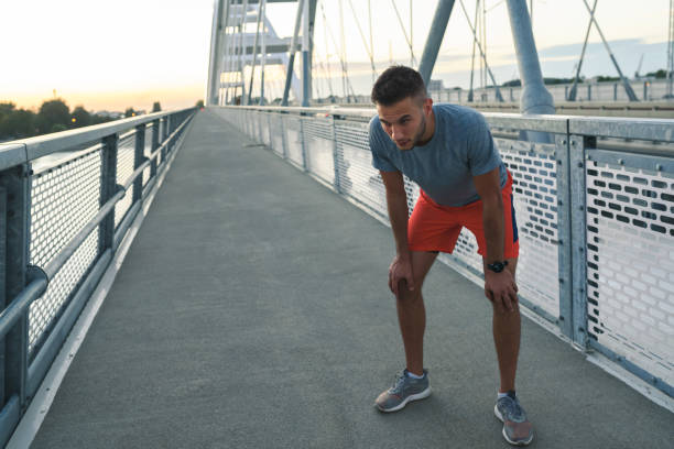 istock Young handsome sporty jogger taking break from exercising outdoors in the sunset 1271398380