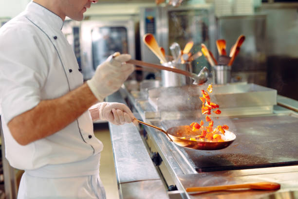 istock Chef cooking vegetables in wok pan. Shallow dof. 1271398806