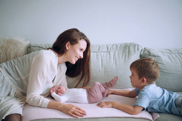 istock Mother and daughter lying on sofa with bigger brother 1271399980