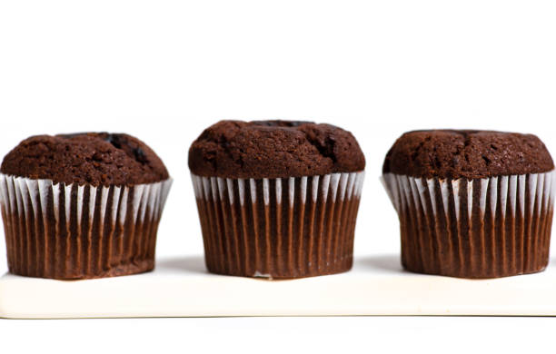 istock Chocolate muffin in a paper cupcake on white background 1271401517