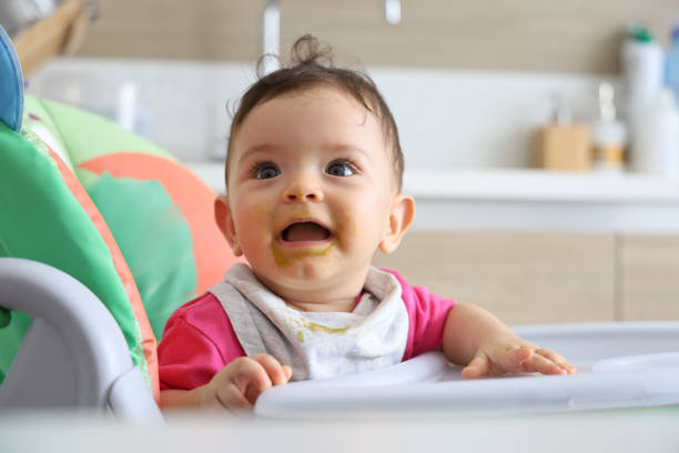 istock Cheerful Baby in Highchair 1271406090
