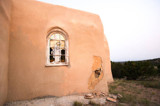 Golden, NM: The historic San Francisco de Asis Catholic Church. Golden is located 40 miles south of Santa Fe on the Turquoise Trail. Pale blue sky background and copy space.