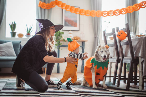 istock Mother helping baby to walk on Halloween 1271408744