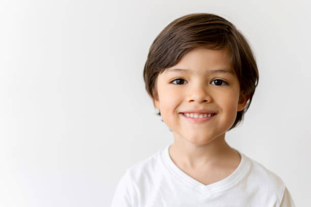 Portrait of a happy Latin American boy smiling Portrait of a happy Latin American boy looking at the camera smiling over a white background one boy only photos stock pictures, royalty-free photos & images