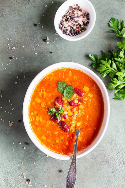 sopa de lentejas y frijoles rojos, caliente y picante, con tomates enlatados y cilantro. fondo concreto, enfoque selectivo. vista superior. - lentil dinner holiday mediterranean cuisine fotografías e imágenes de stock