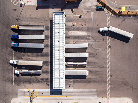 Aerial shot looking directly down on a row of trucks refueling at a truck stop in Texas.