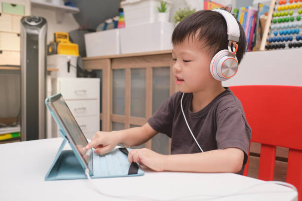 asiático niño niño niño de 4 años usando tableta pc ordenador, niño en casa durante la crisis de salud covid-19, aprendizaje a distancia, actividades para el concepto de jardín de infantes - 4 5 years fotografías e imágenes de stock