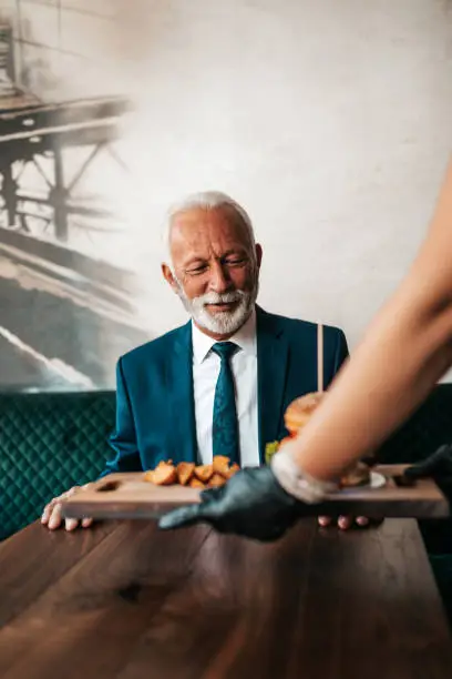 Photo of Senior businessman at restaurant table