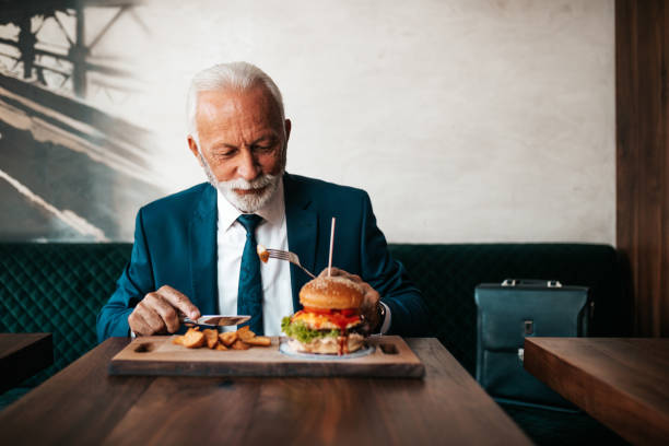 istock Senior businessman at restaurant table 1271415999