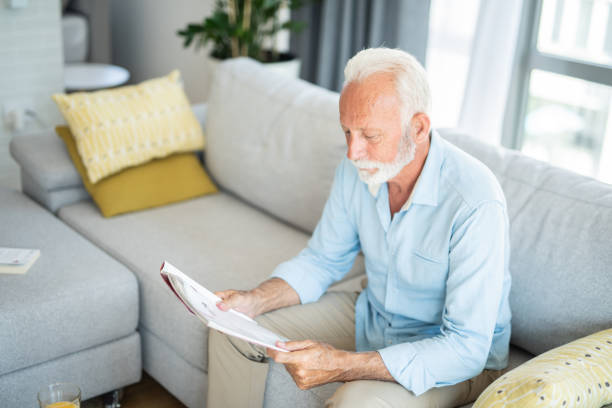 istock Senior man reading a magazine at home. 1271416401