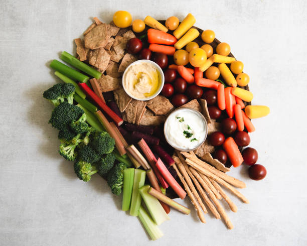 istock Flat lay of fresh vegetables, hummus, bread sticks and yogurt dips on rustic table 1271421995