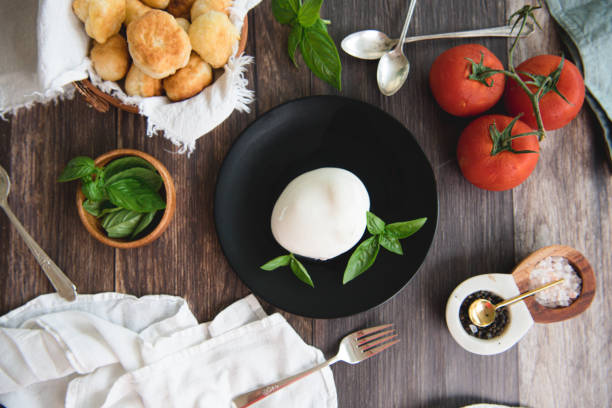 lay piatta di mozarella fresca, pomodori, basilico e pane fresco fatto in casa - mozarella sul tavolo foto e immagini stock