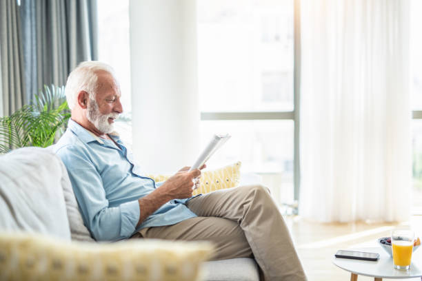 istock Senior man reading a magazine at home. 1271423158