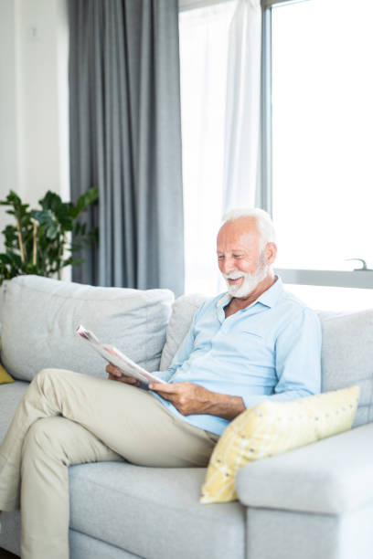 istock Senior man reading a magazine at home. 1271424178