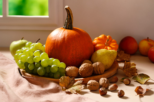 Thanksgiving cornucopia background with apples, grapes. pears, gourd, squash and nuts.
