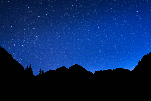Maroon Bells Silhouette at Night with Stars - Night astrophotography with 14er mountains North and South Maroon Peaks, Aspen, Colorado USA.