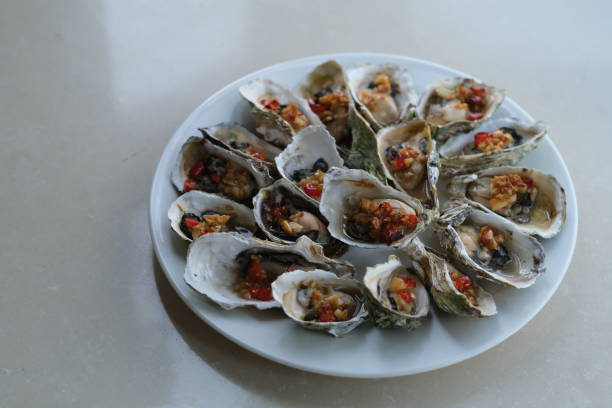 istock close up a plate of grilled oysters with spice on white table. 1271430676