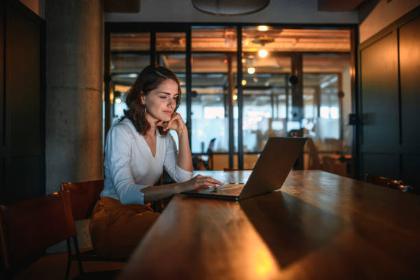 istock Young Brunette Businesswoman Working in Low Light Board Room 1271431594