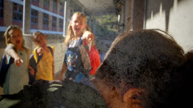 Group of school kids making fun of a boy in school against flickering background