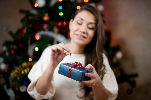 girl opens a gift for the new year. Opening a Christmas gift. Focus on the gift